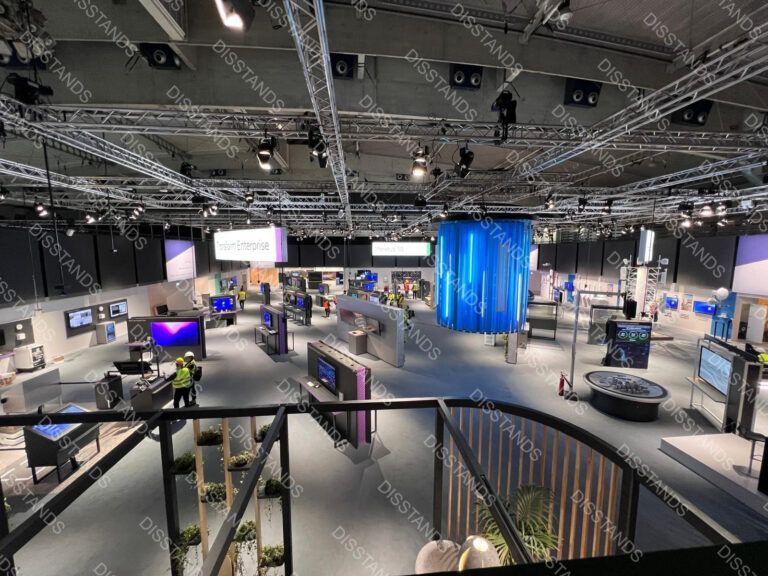 Instalación de moquetas para Mobile World Congress Barcelona, pavimento gris en pabellón de exposición con stands tecnológicos y áreas de networking
