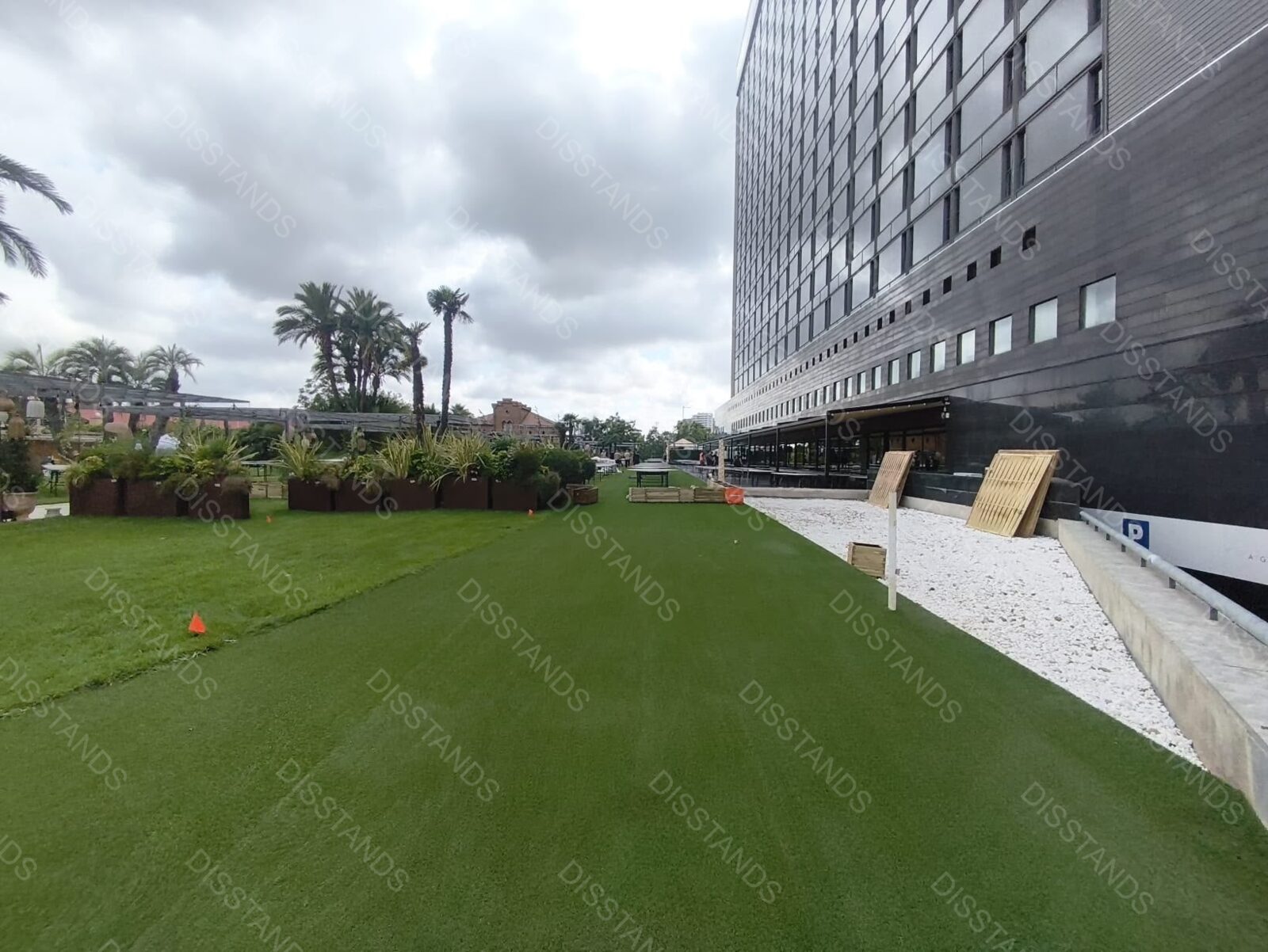 Césped Bredis 30MM - Pradera frente a hotel con palmeras